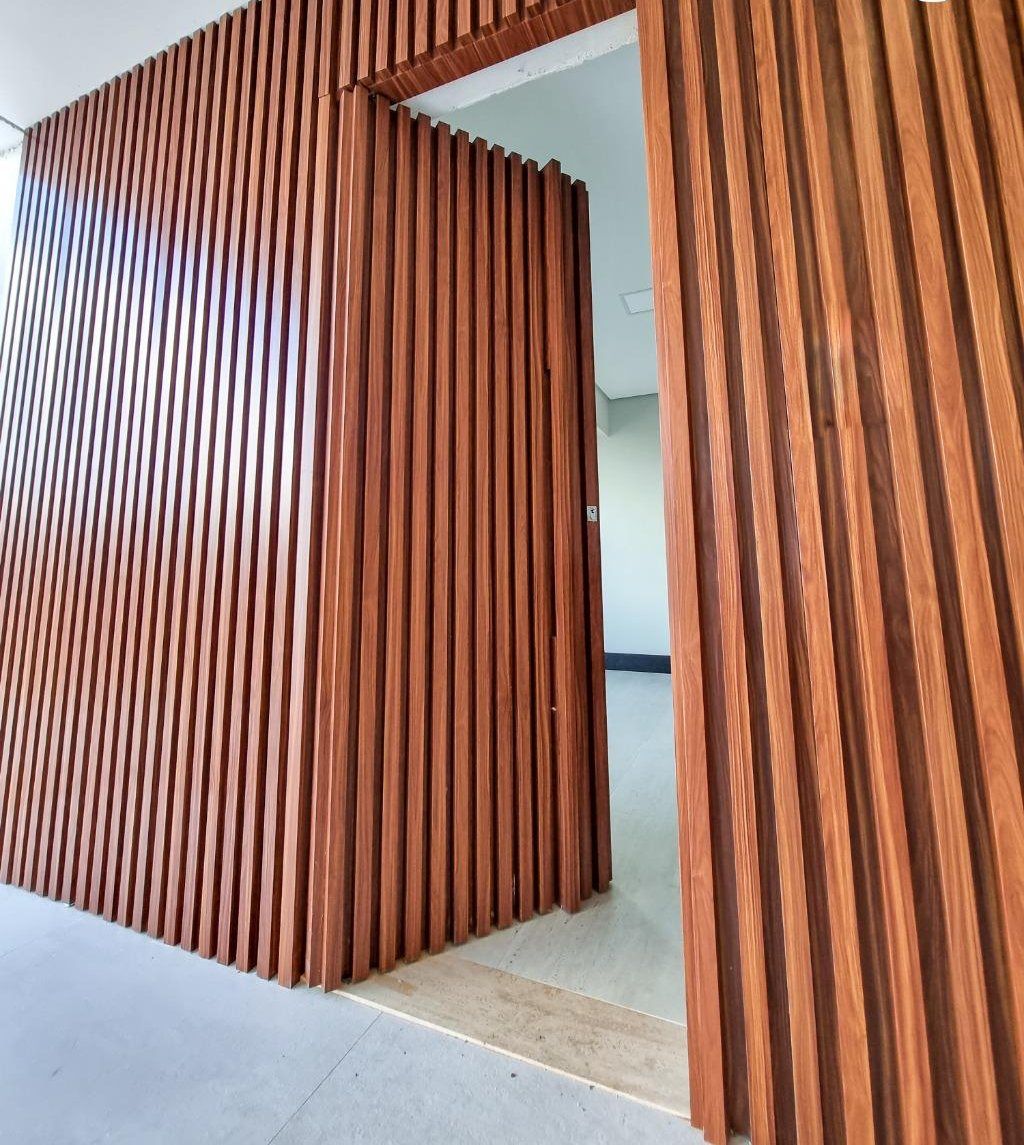 Painel de madeira ripada com porta embutida, sem batente aparente